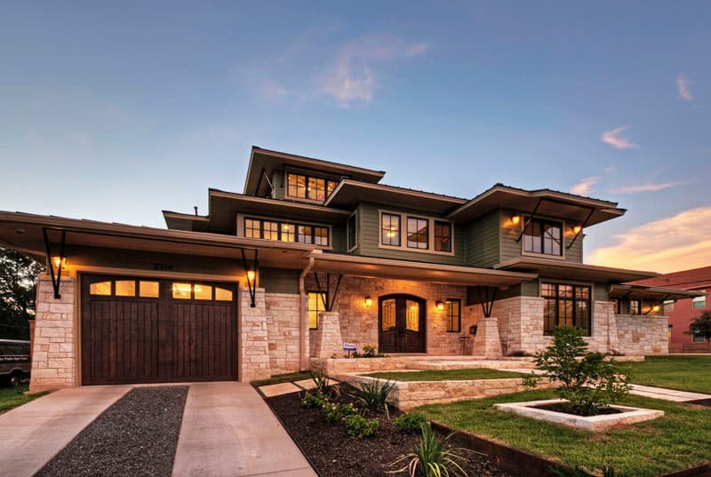 Stone home with new front landscaping at dusk